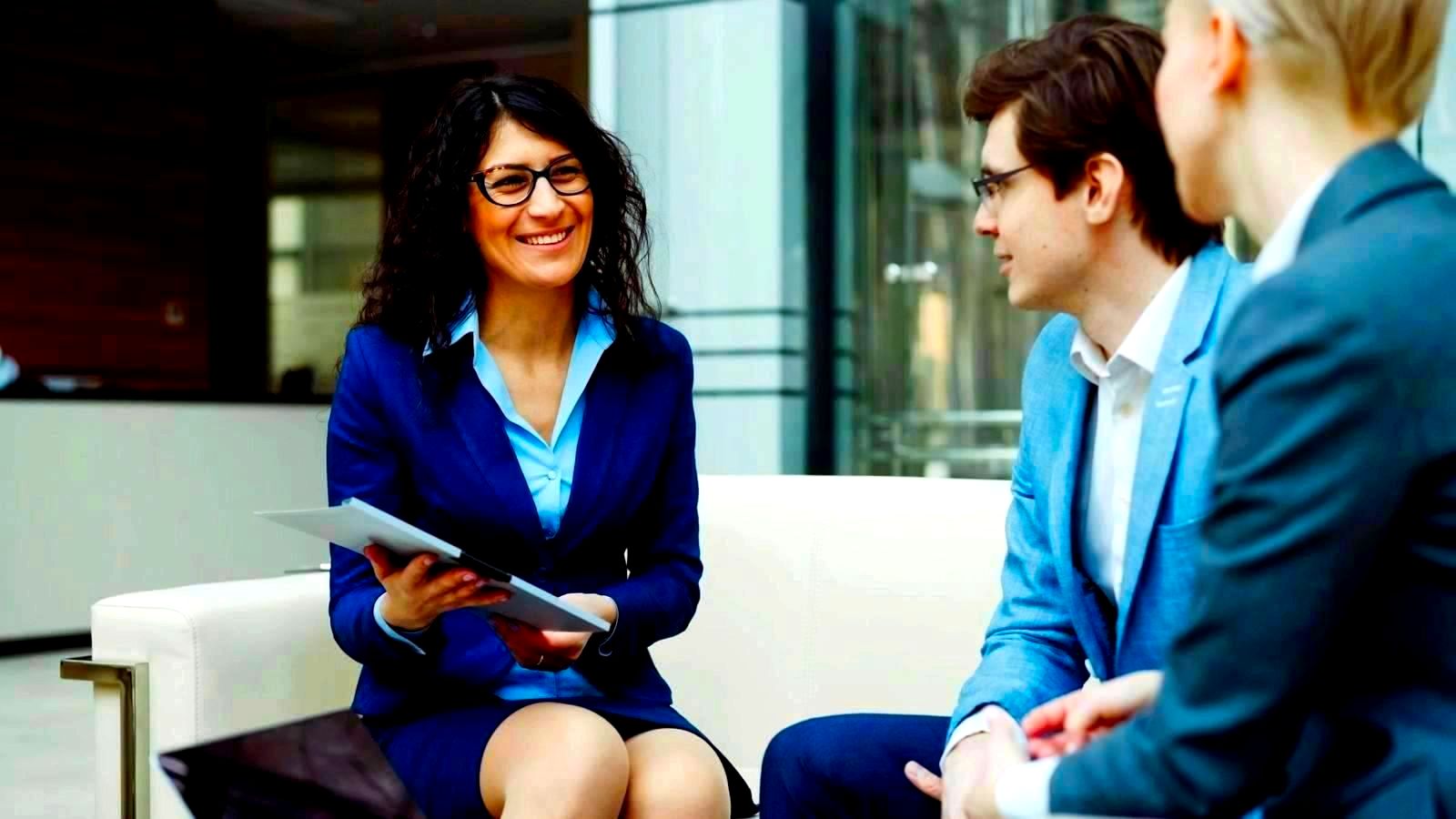 Business professionals gathered around a table in a modern office lounge