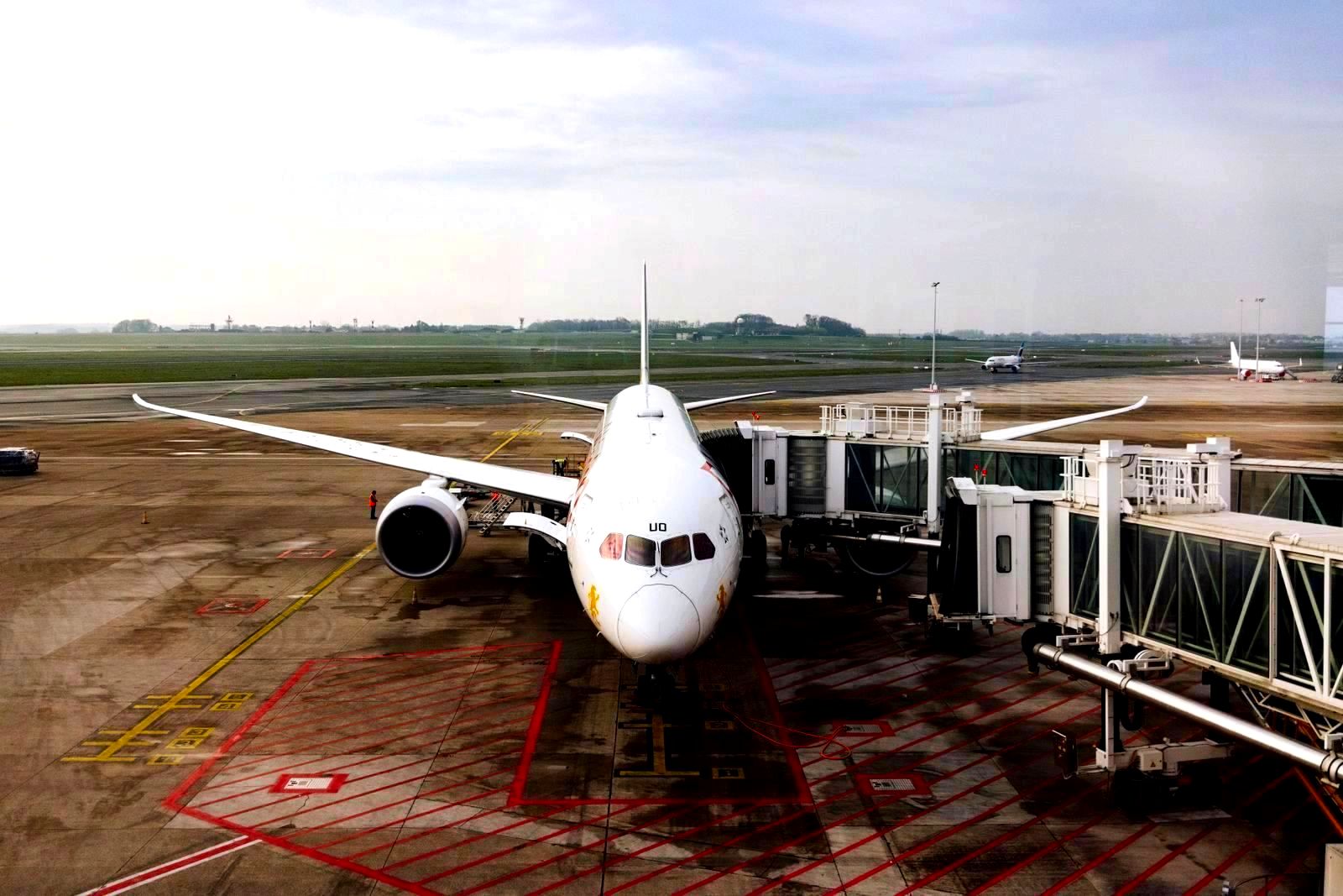 Modern jet airplane docked at airport terminal gate on cloudy day