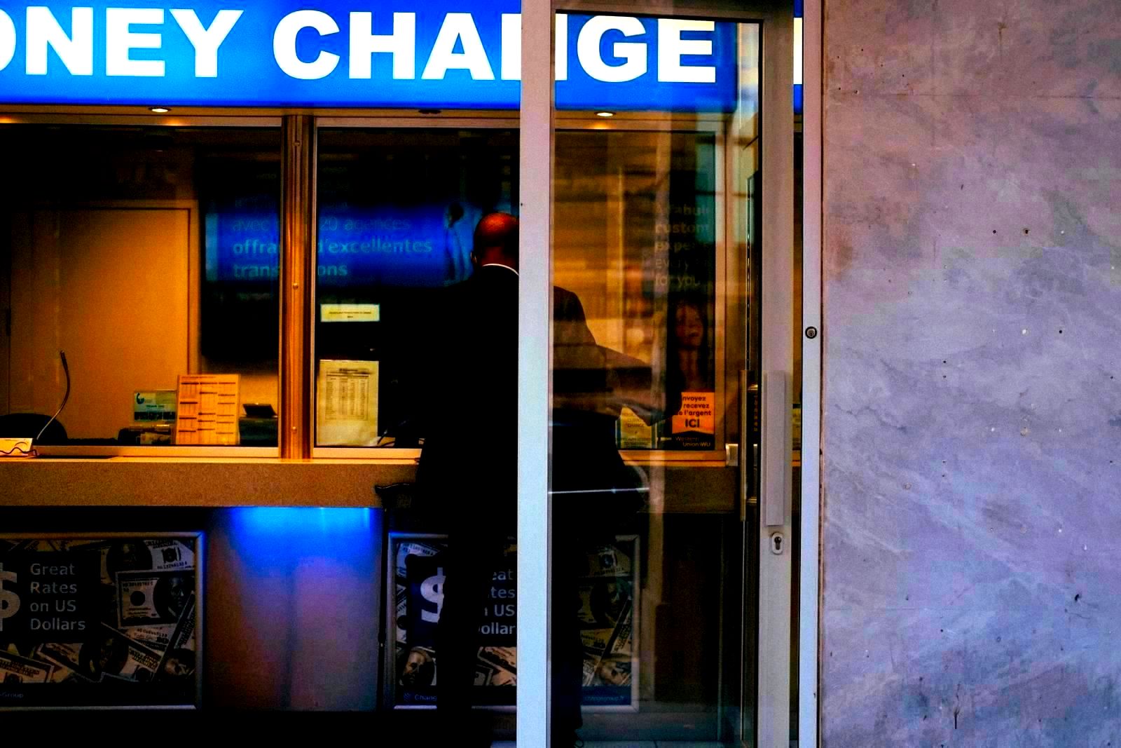 Man at a bank currency exchange office window in a city
