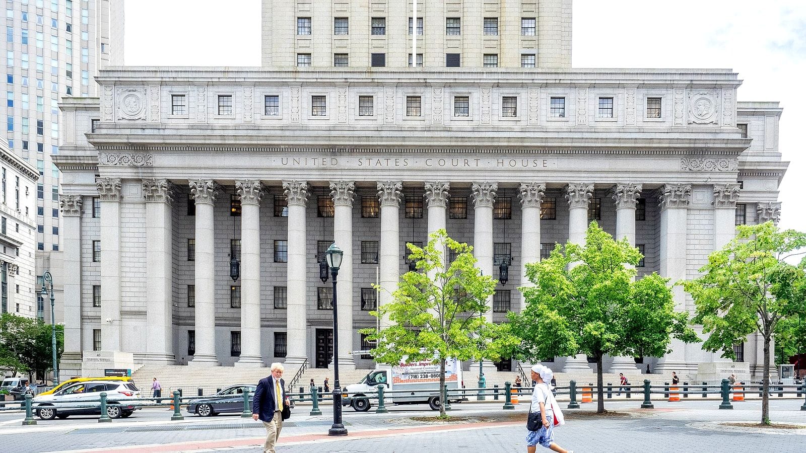 The columned facade of the Thurgood Marshall United States Courthouse in Manhattan, with UNITED STATES COURT HOUSE carved above the columns and pedestrians crossing the plaza in front