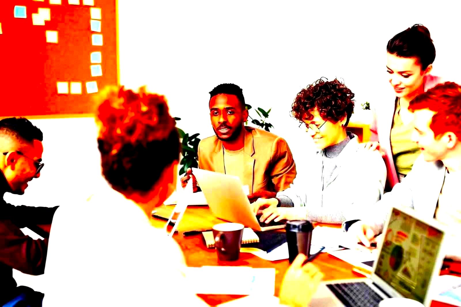 Professionals of various backgrounds working together at computers in an office