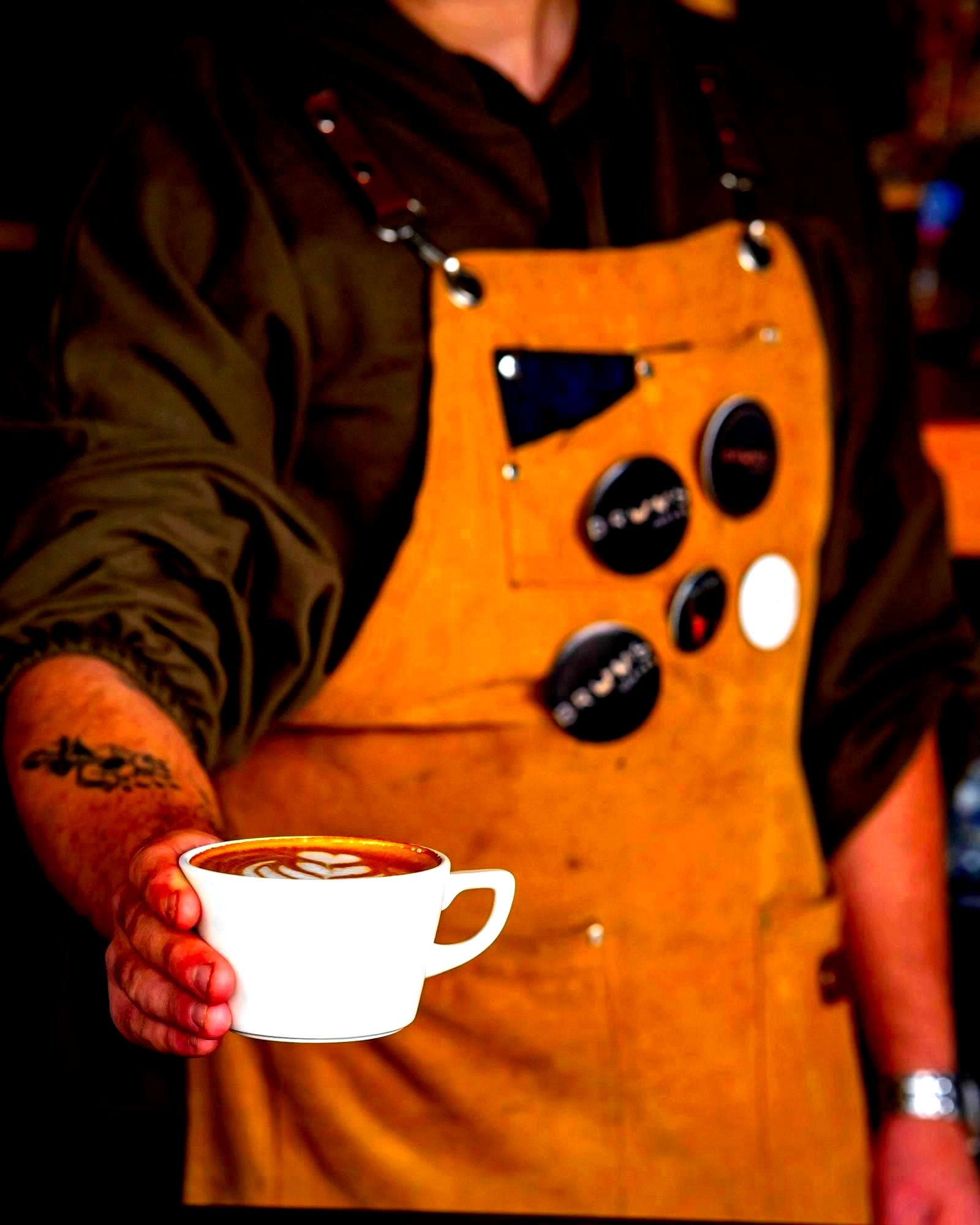 Barista serving a latte in an artisan coffee cafe