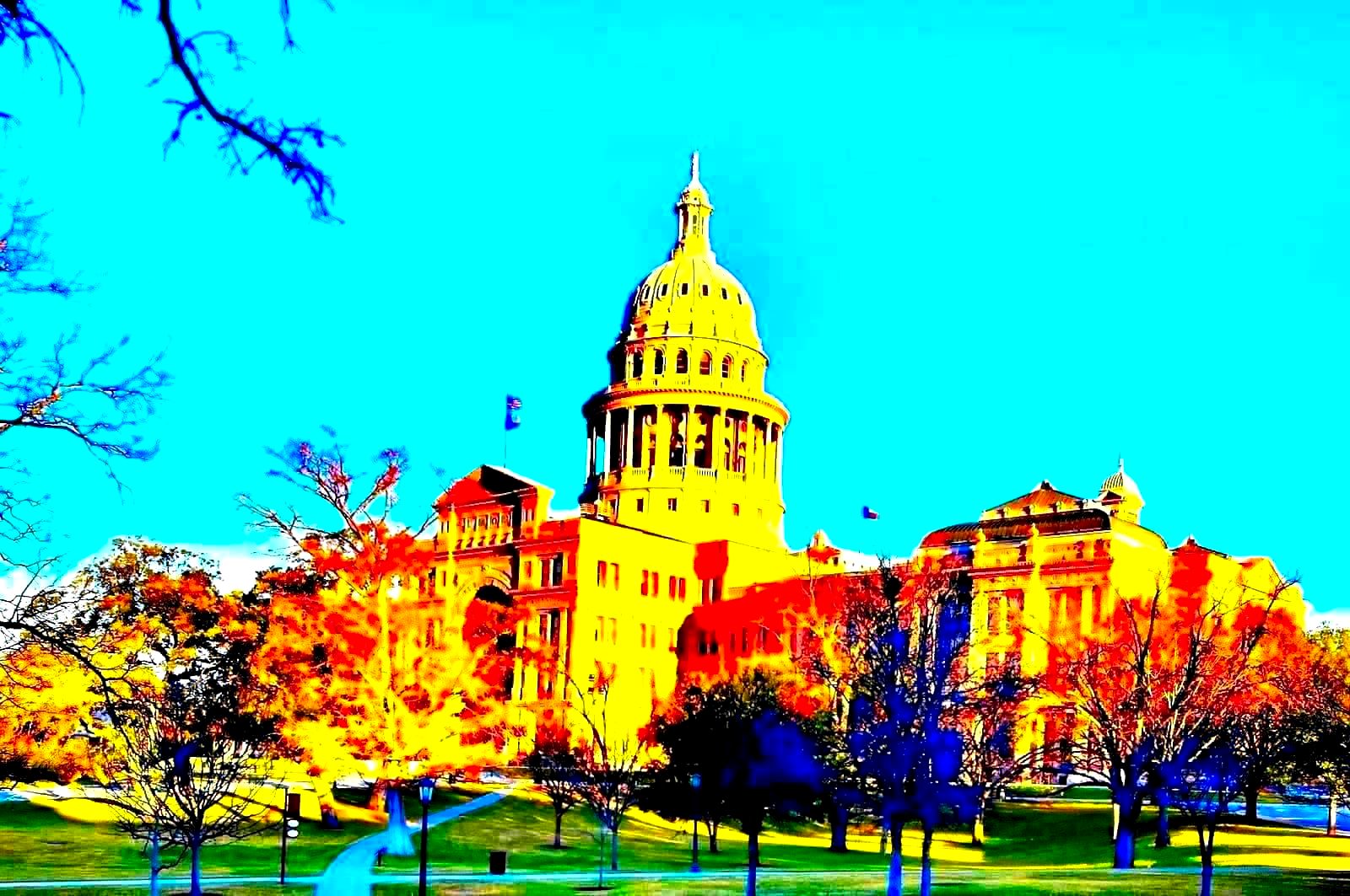 A state capitol building dome at dusk with American flag