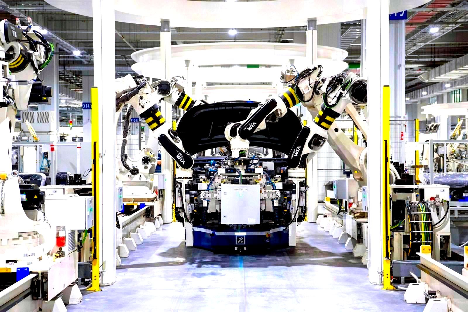 Workers assembling machines on a car factory assembly line