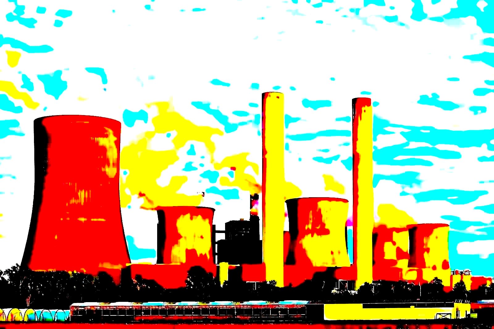 Industrial factory chimneys emitting smoke against a clear sky, representing operational reality behind sustainability marketing